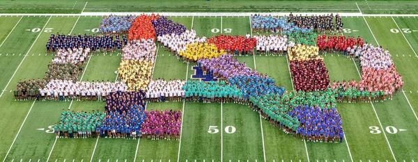The Class Of 2025 organized to form the ND monogram on the 50-yard-line of Notre Dame Stadium