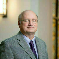Scott Appleby is an older gentleman with thinning hair and wire-rimmed glasses, wearing a light purple shirt and dark purple tie
